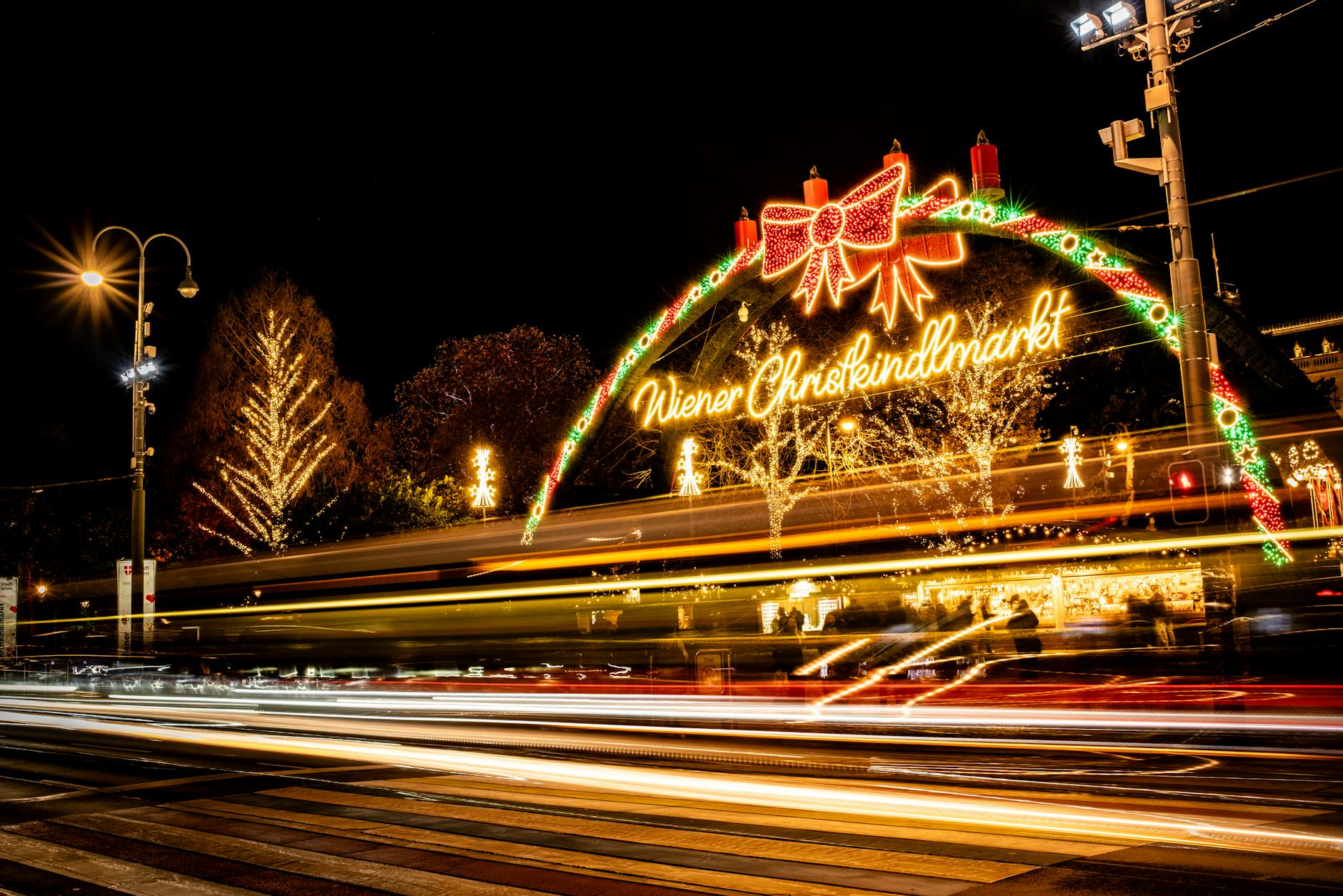 Colorful lights and lively atmosphere at Vienna's iconic Christmas market captured at night.