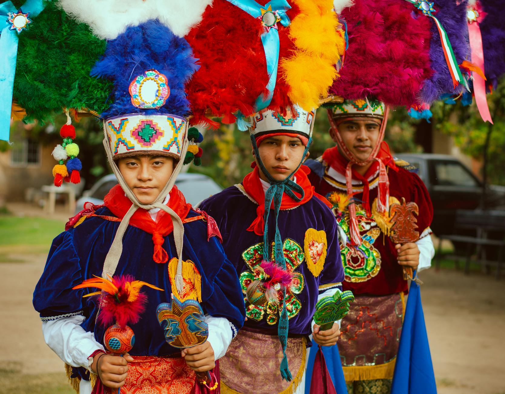 Colorful traditional Mexican costumes worn by festive participants at an outdoor cultural event.